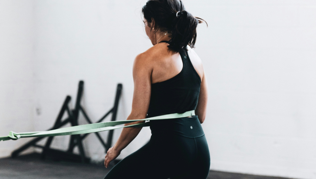 Mujer entrenando en casa con sus accesorios deportivos