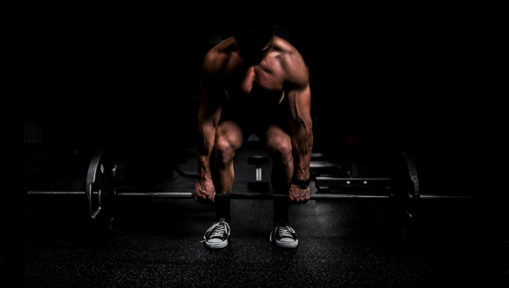 Hombre entrenado fuerte gracias a los mejores suplementos para ganar masa muscular